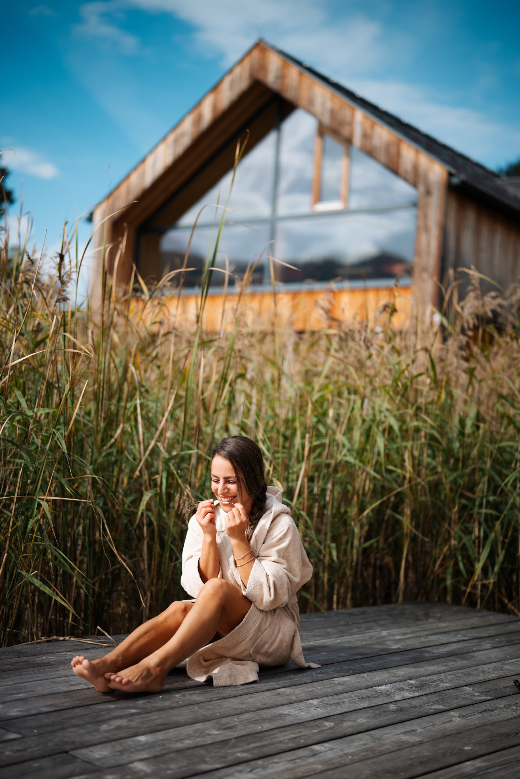 Frau im Bademantel am Schilf vor dem Chalet